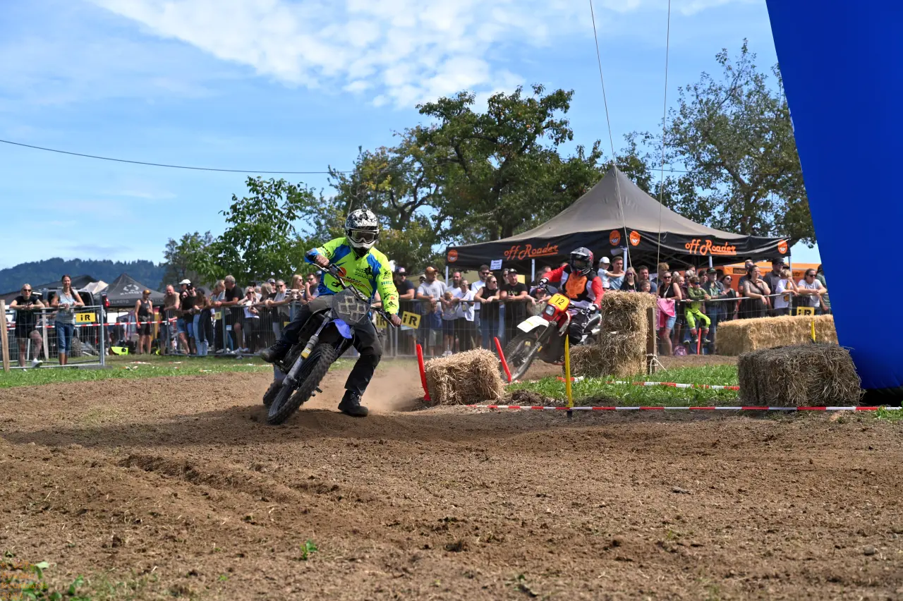 Zwei Motorradfahrer in Schräglage vor den Zuschauern beim Off-Roader Rennen